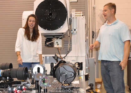IMAGE: DAHLGREN, Va. (July 10, 2018) - Sarah Wessel and her mentor, Naval Surface Warfare Center Dahlgren Division engineer Matt Henning, examine the Advanced Beam Control Locating and Engaging - Enhanced Tracking System (ABLE-ETS) gimbal. The ABLE ETS Gimbal is part of a pointing and image tracking system. Last summer, Wessel converted the gimbal's pointing controller Simulink code into C++ code. ABLE-ETS is a Joint Technology Office funded test bed for maturing directed energy and high-energy laser technologies, including tracking, sensors, and lasers. 

Wessel is interning at Dahlgren through the STEM (science, technology, engineering and mathematics) Student Employment Program (SSEP). The program provides direct hire authority for undergraduate and graduate degree seeking students enrolled in STEM majors. The program was established to provide interns with exposure to public service, enhance educational experience, and possibly provide financial aid to support educational goals. Additionally, this program will provide a streamlined and accelerated hiring process to compete successfully with private industry for high-quality scientific, technical, engineering, or mathematics students for filling scientific and engineering positions.