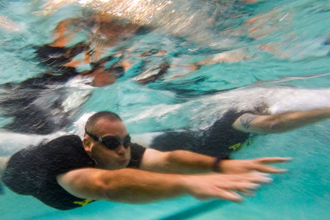 A soldier dives into a pool.