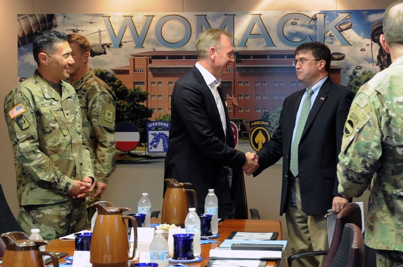 Deputy Defense Secretary Patrick M. Shanahan greets Veterans Affairs Secretary Robert Wilkie.