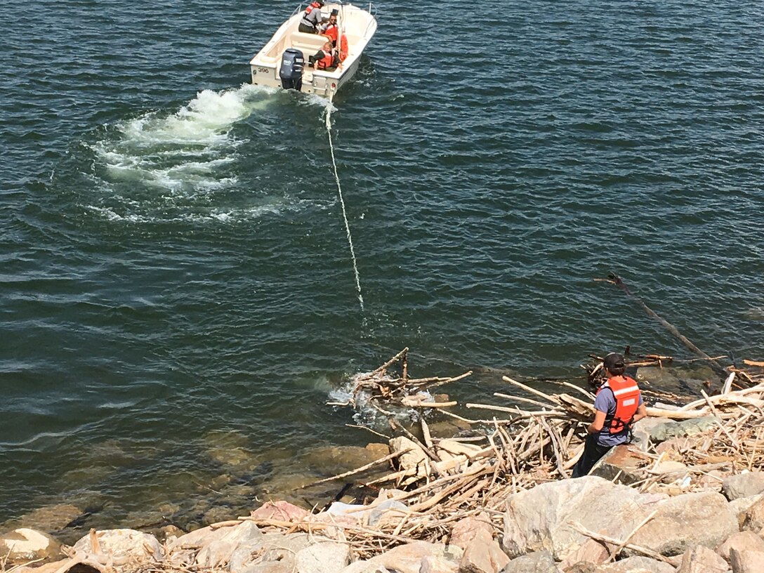 Crews at the Garrison Dam in North Dakota are removing logs and debris from the approach channel and embankment near the spillway.