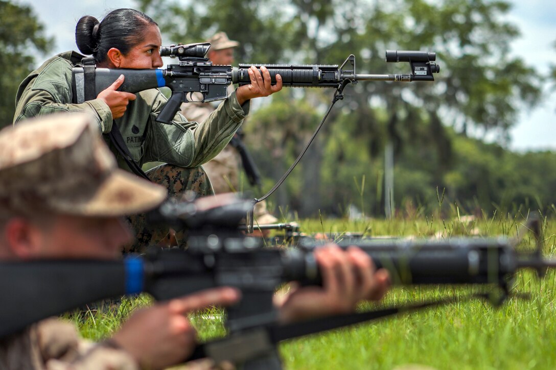 Marine Corps Staff Sgt. Estefania Patino corrects the optics on a weapon.