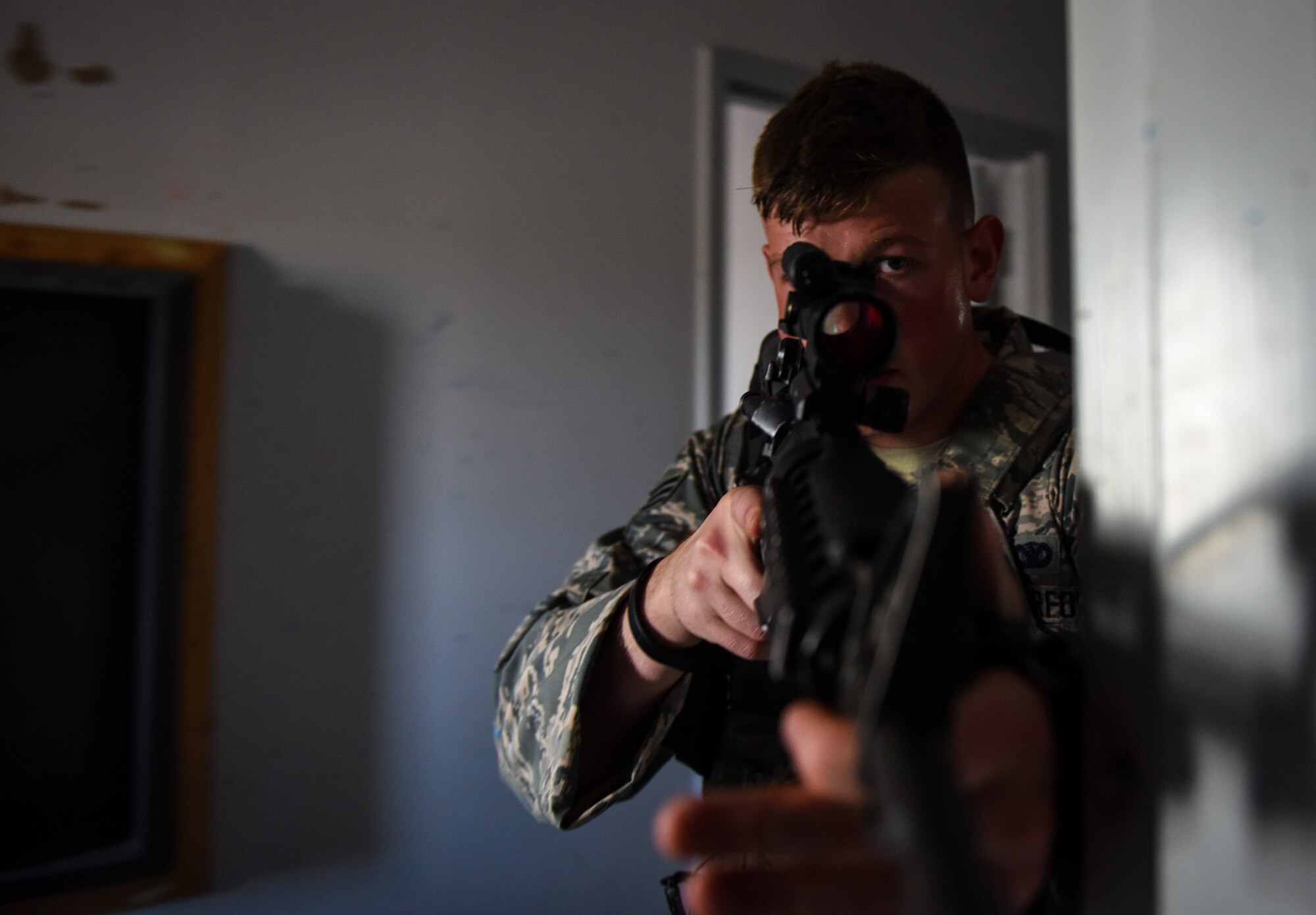 Senior Airman Nicholas Rauch, 460th Security Forces Squadron defender, sweeps a hallway during a field exercise in preparation for the Defenders Challenge July 27, 2018, on Buckley Air Force Base, Colorado. Buckley AFB defenders trained in simulated situations such as hostage recovery and neutralizing active shooters. (U.S. Air Force photo by Airman 1st Class Michael D. Mathews)