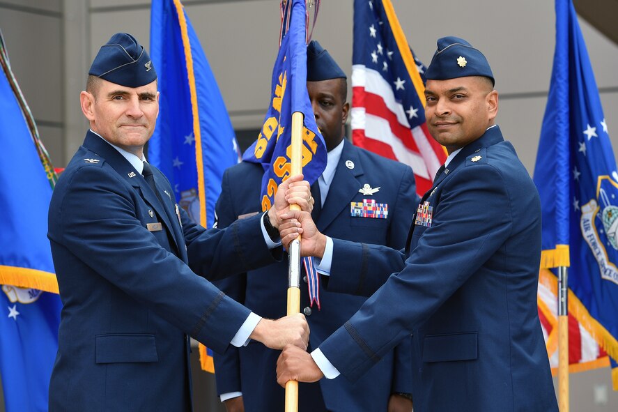 Col. Hewett Wells, commander of the 50th Network Operations Group, hands the 22nd Space Operations Squadron guidon to Maj. Sanil Amin new commander of the 22nd SOPS during a change of command ceremony at Schriever Air Force Base, Colorado, July 27, 2018.  Maj. Amin assumed command from Lt. Col. Lewis Sorvillo. (U.S. Air Force Photo/Dennis Rogers)