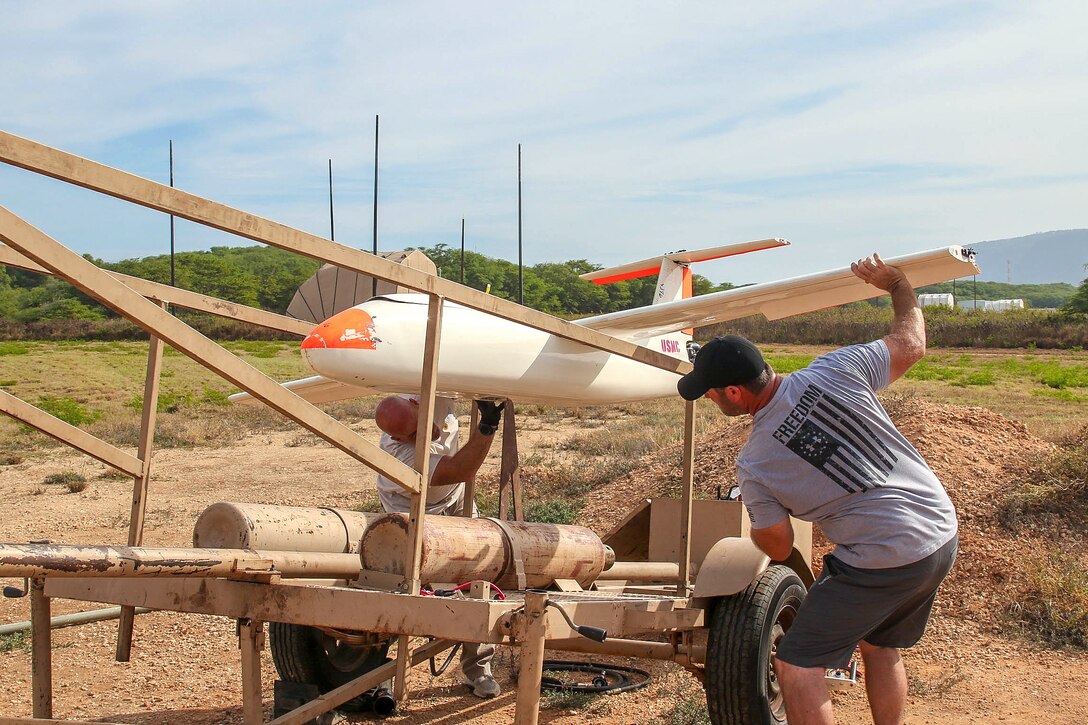 Civilian contractors prepare an unmanned aerial vehicle for launch.