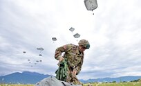 A U.S. Army Paratrooper, assigned to the 173rd Brigade Support Battalion, 173rd Airborne Brigade, secures his equipment after exiting a U.S. Air Force 86th Air Wing C-130 Hercules aircraft, during airborne operation at Juliet Drop Zone in Pordenone, Italy May 22, 2018.