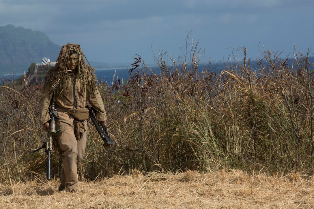 A U.S. Marine Corps scout sniper with 1st Battalion, 3rd Marine Regiment, reveals himself during the amphibious landing demonstration as part of Rim of the Pacific exercise on Marine Corps Base Hawaii July 29, 2018. RIMPAC provides high-value training for task organized, highly capable Marine Air-Ground Task Force and enhances the critical crisis response capability of U.S. Marines in the Pacific. Twenty-Five nations, 46 ships, five submarines, about 200 aircraft, and 25,000 personnel are participating in RIMPAC from June 27 to Aug. 2 in and around the Hawaiian Islands and Southern California.