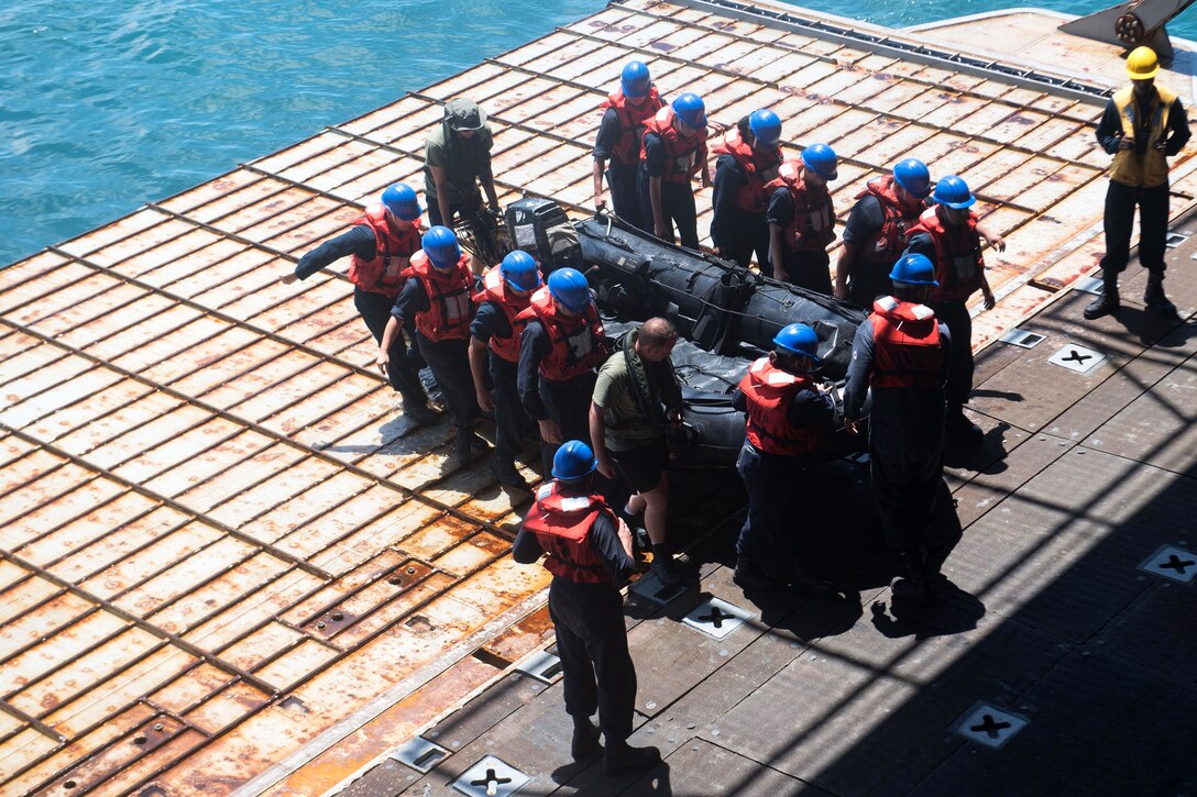 U.S. sailors and sailors from the Netherlands carry a combat rubber raiding craft.