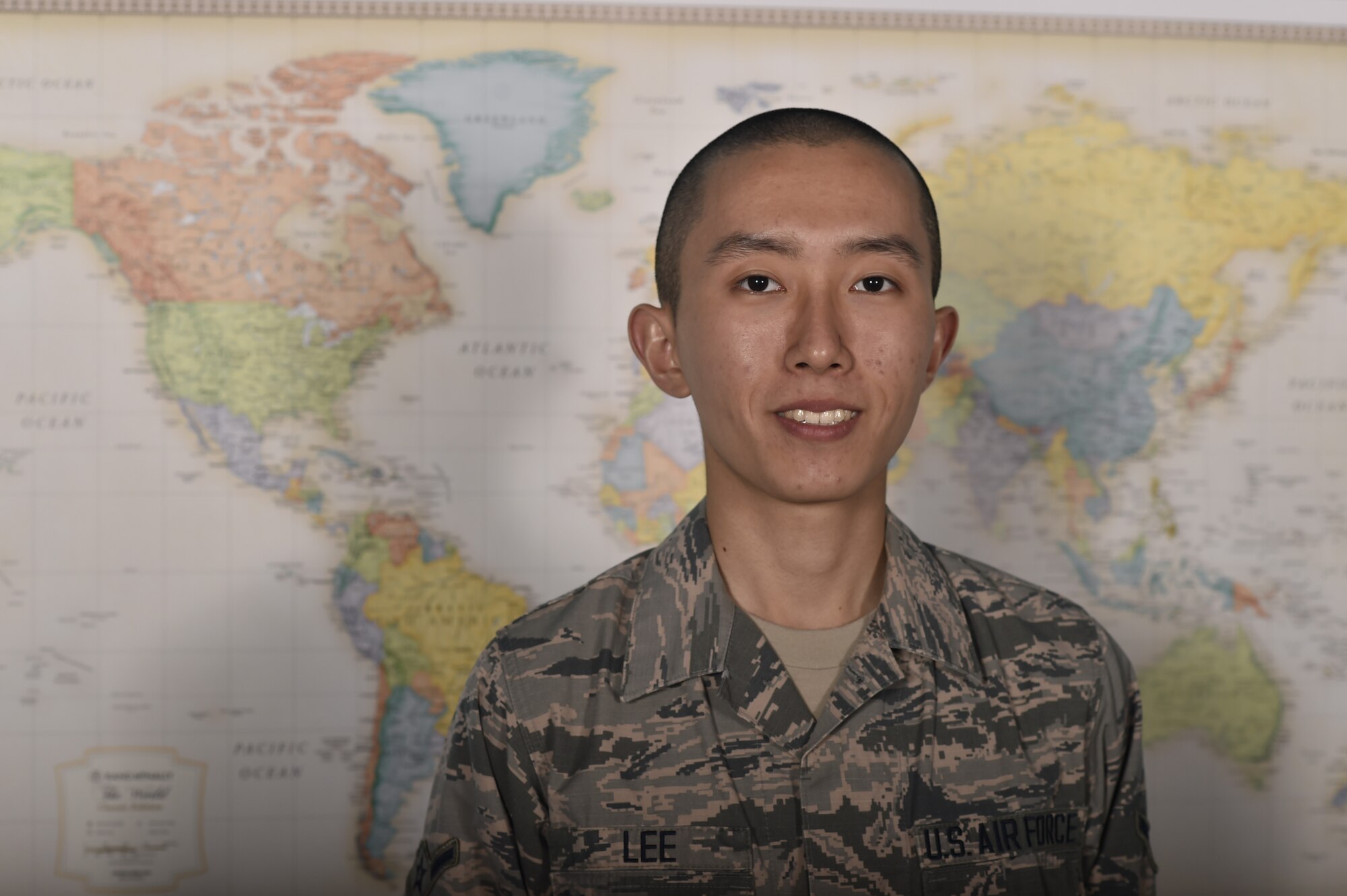Airman Junjhyun Lee, a 319th Comptroller Squadron debt management apprentice, stands in front of a world map June 11, 2018, on Grand Forks Air Force Base, North Dakota. Lee is originally from Seoul, South Korea, and joined the Air Force for the education and career opportunities. (U.S. Air Force photo by Airman 1st Class Melody Wolff)
