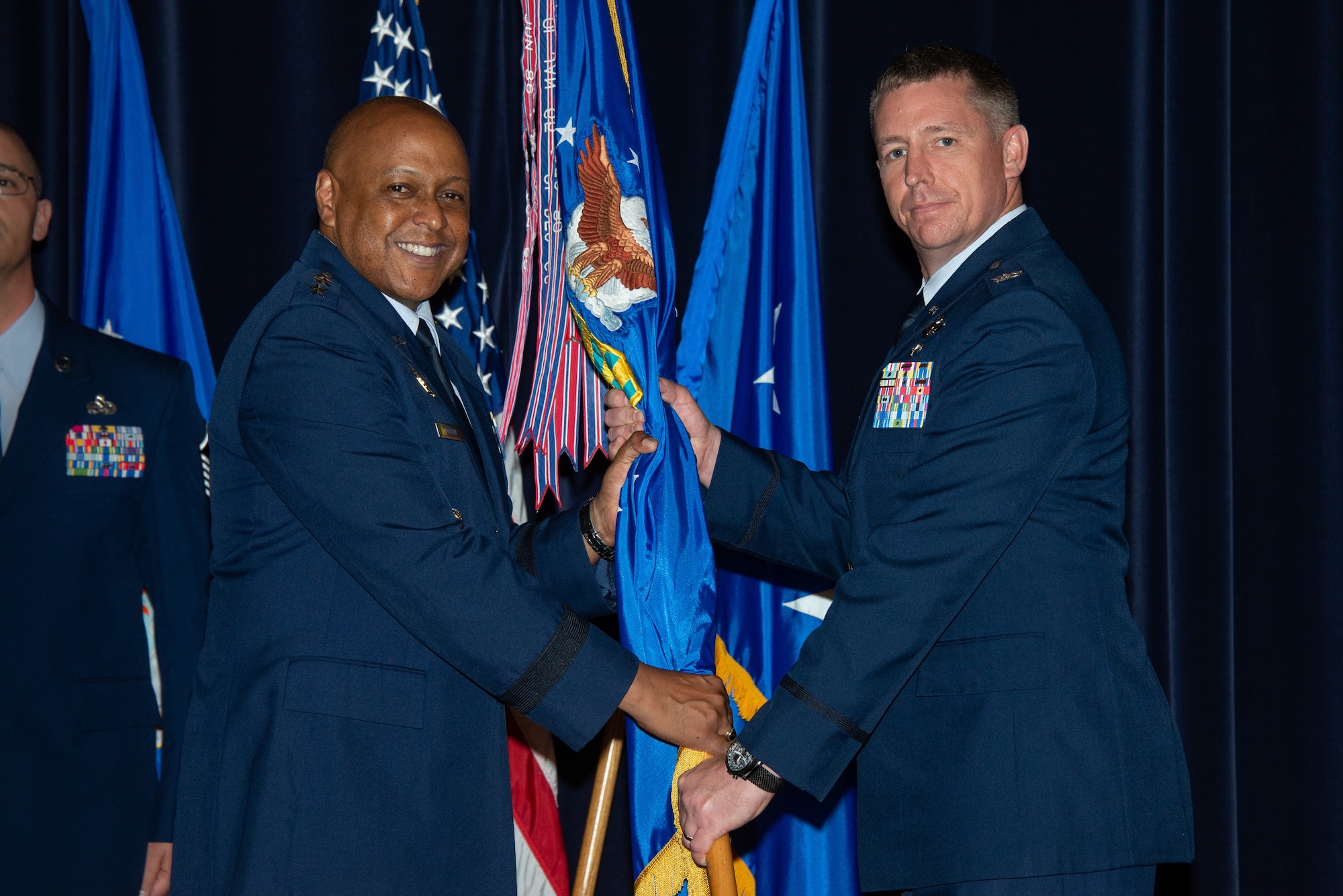 Maxwell AFB, Ala. - Lieutenant General Anthony Cotton, commander and president of Air University (left), presents the Air Command and Staff College guidon to Col. Evan Pettus during a change of command ceremony, July 27, 2018. Air Command and Staff College is the in-residence and distance learning professional military education college of midcareer officers and civilians, focused on the development of air-minded joint leaders.(US Air Force photo by Melanie Rodgers Cox)