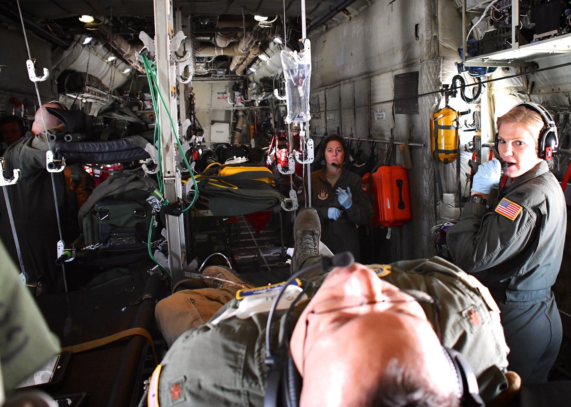 The 932nd Airlift Wing’s Aeromedical Evacuation Squadron flew aboard a packed and busy medical practice training flight on July 22, 2018.  They flew aboard a C-130 aircraft, provided by the 910th Airlift Wing. After taking off from Scott Air Force Base, Illinois, 1st Lt. Liz Erdman, 932nd AES flight nurse, and Senior Master Sgt. Tonya Hupp, AES superintendent, listen to a "simulated patient" describing his injuries.  Together, the Airmen aboard reviewed Air Force Instructions covering medical issues.  The aeromedical training featured interaction and communication between medical personnel and loadmasters taking care of equipment aboard the plane.   (U.S. Air Force photos by Lt. Col. Stan Paregien)