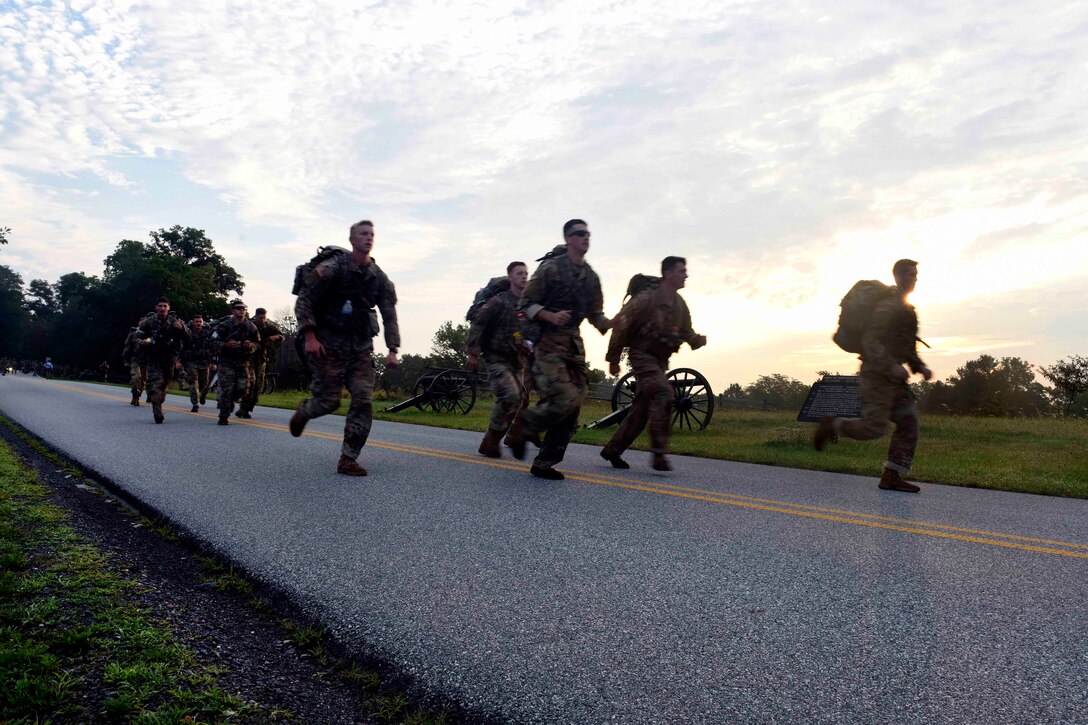 Soldiers run along a road during the ruck march event.