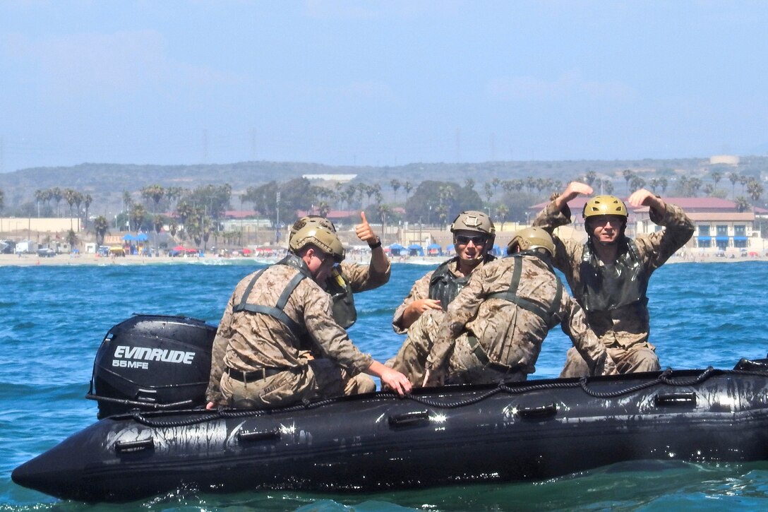 U.S. Marines and Australian sailors climb into combat rubber raiding craft.
