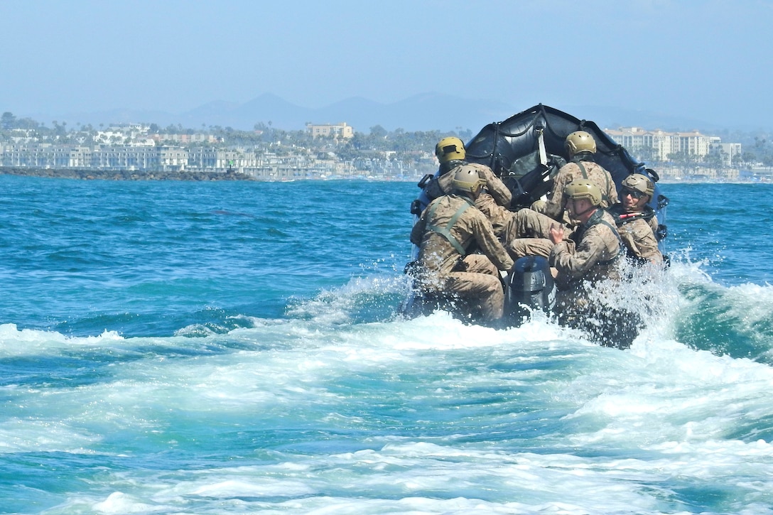 U.S. Marines and Australian sailors ride in combat rubber raiding craft.