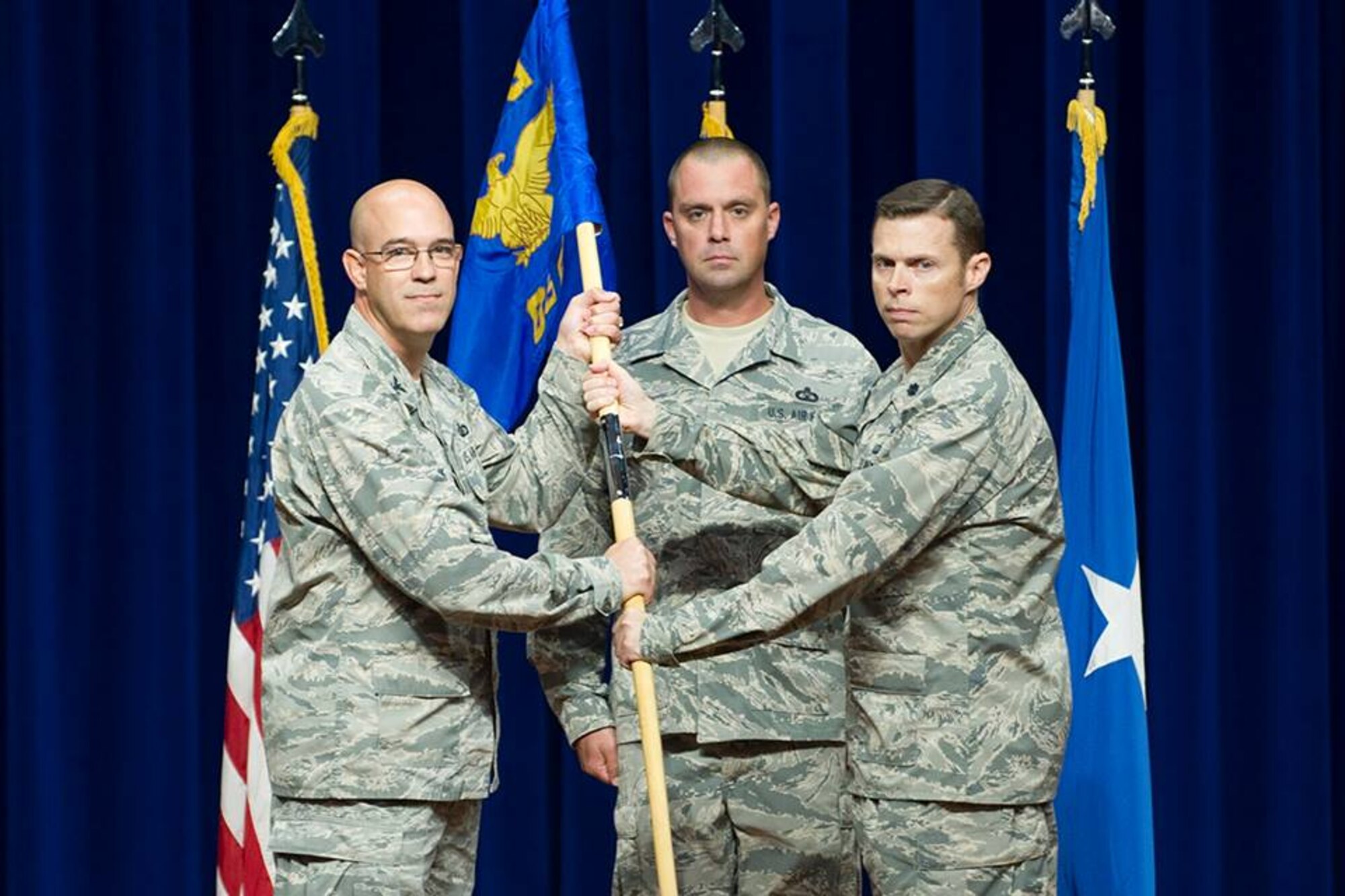 Col. Steven Lang, commander of the 45th Operations Group, presents Lt. Col. Gregory Vice, commander of the 45th Range Squadron, the 45th RANS guidon, July 31, 2018, at Patrick Air Force Base, Fla. The 45th Operations Support Squadron and 1st Range Operations Squadron inactivated and merged its mission and personnel together, now a single squadron, the 45th RANS. (U.S. Air Force photo by Phillip Sunkel)