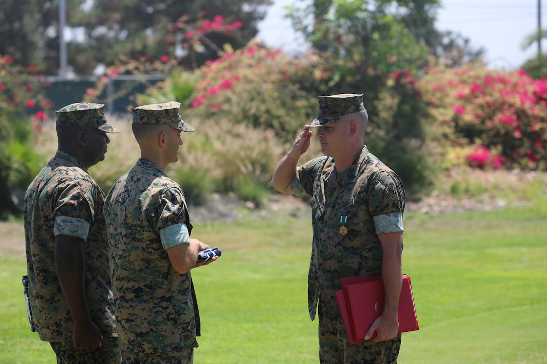 U.S. Marine Corps Master Sgt. Geanni Zillinger, station food service technical representative, salutes the national ensign before receiving it from Lt. Col. Michael A. Spears, commanding officer of Headquarters and Headquarters Support Squadron, during Master Sgt. Zillinger’s retirement ceremony at Marine Corps Air Station Miramar, Calif., July 27. Zillinger retired after serving 26 years of honorable military service. (U.S. Marine Corps photo by Sgt. Daniel Auvert/Released)
