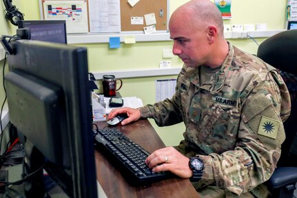 Army Maj. Nathan Wall, of the California Army National Guard’s 40th Infantry Division and the deputy logistics officer for Train, Advice and Assist Command-South in Afghanistan, checks email in his office in Kandahar Airfield, Afghanistan. While Wall may be known overseas for working in logistics, back home in Loma Linda, California, he is known as Dr. Wall and teaches a molecular genetics and biochemistry at Loma Linda University School of Medicine.