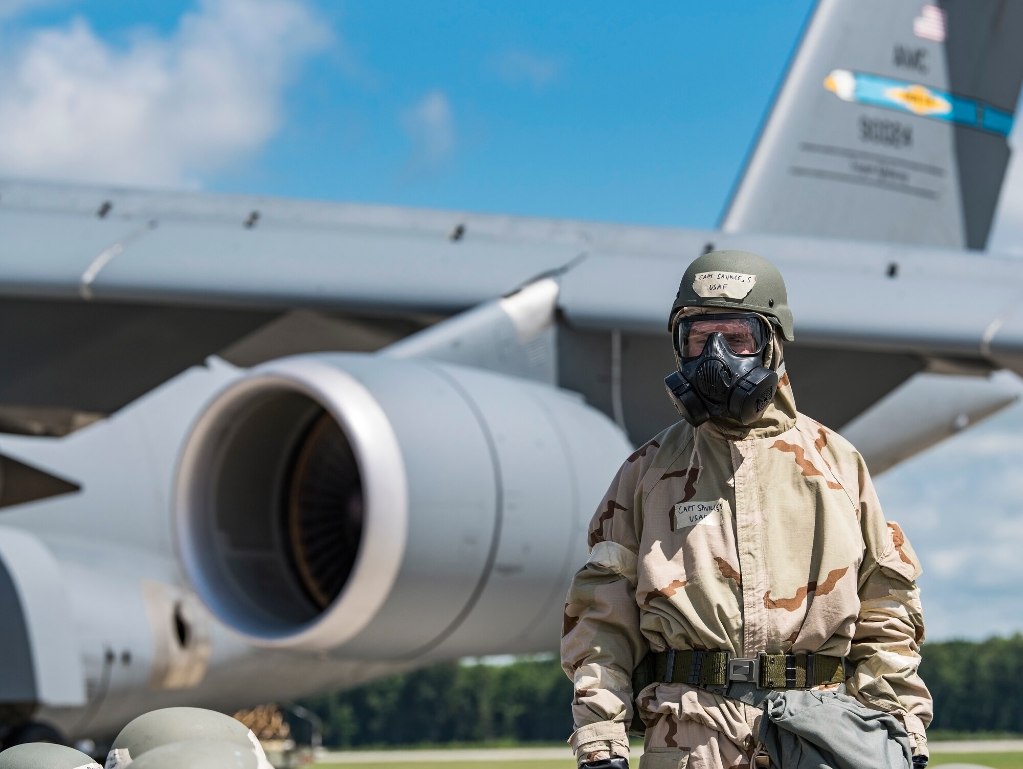 Capt. Scott Saville, 9th Airlift Squadron C-5M Super Galaxy pilot, monitors personnel on the flight line in protective gear to test chemical, biological, radiological and nuclear hazard defensive measures July 26, 2018, at Dover Air Force Base, Del. Scott was a member of a preflight crew consisting of aircrew, maintenance and aerial port personnel tasked to prepare the C-5M for flight during exercise Vengeant Eagle 2.0. (U.S. Air Force photo by Roland Balik)