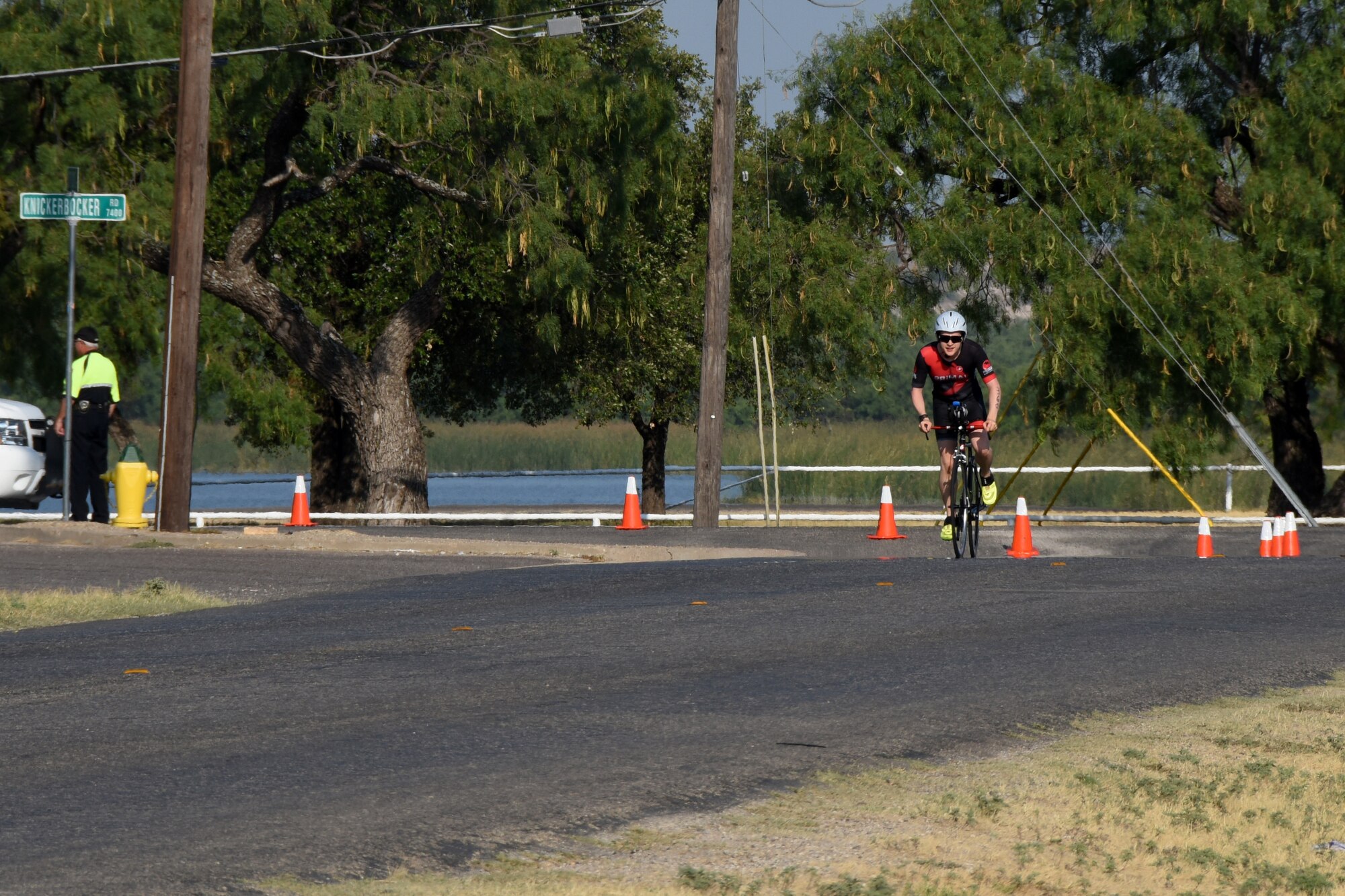 Triathlon participant Josh Holtkort, rounds a turn on his way towards the end of the 20K cycling section of the Goodfellow Annual Triathlon at the Goodfellow Air Force Base Recreation Camp San Angelo, Texas, July 28, 2018. Once participants were done with the cycling portion of the triathlon, there was a 5K run left between them and the finish line. (U.S. Air Force photo by Airman 1st Class Zachary Chapman/Released)