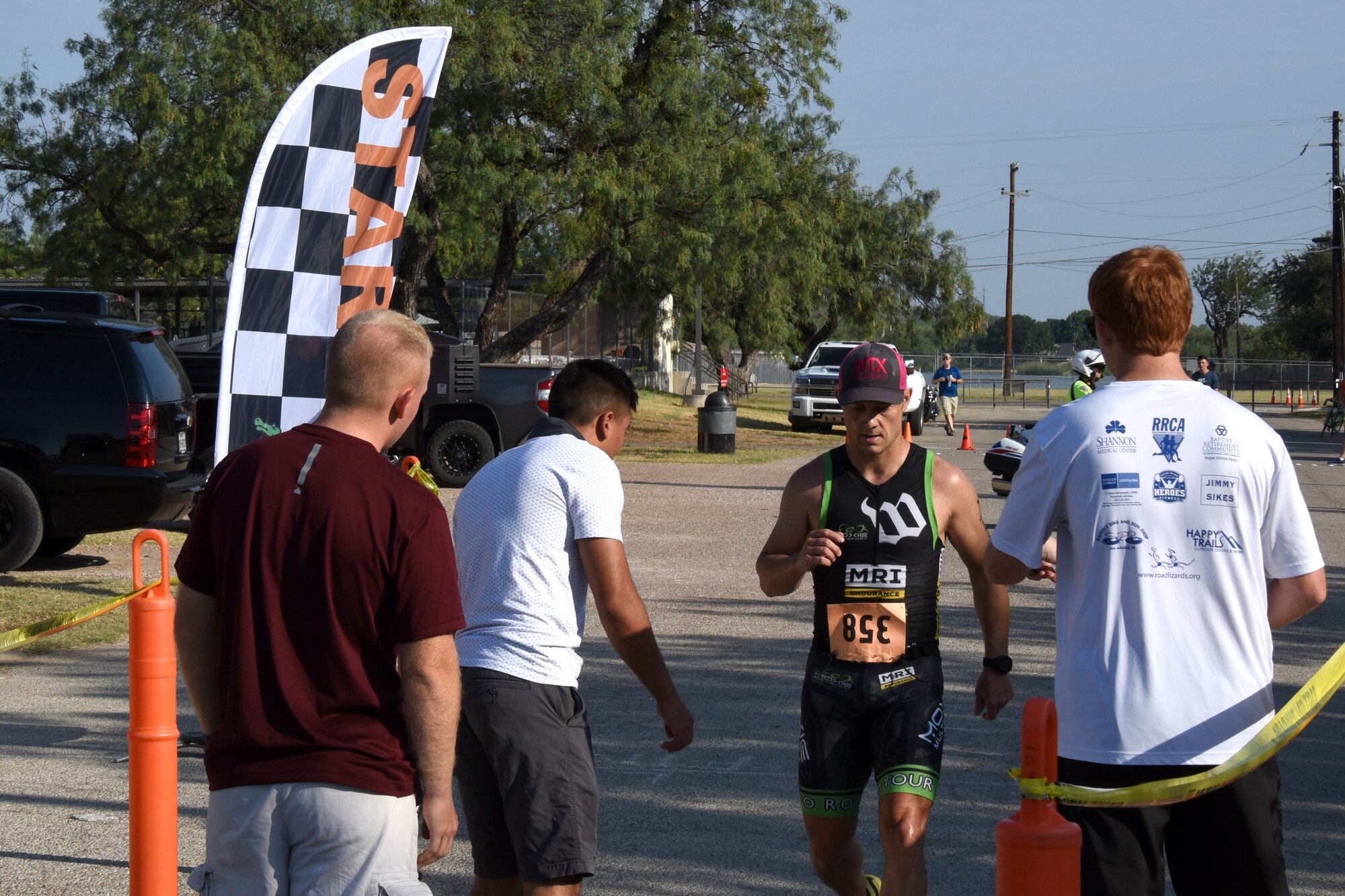 Triathlon participant Roy Basham, crosses the finish line during the Goodfellow Annual Triathlon at the Goodfellow Air Force Base Recreation Camp San Angelo, Texas, July 28, 2018. Basham came in first during the triathlon with a time of 1:03:31 (U.S. Air Force photo by Airman 1st Class Zachary Chapman/Released)