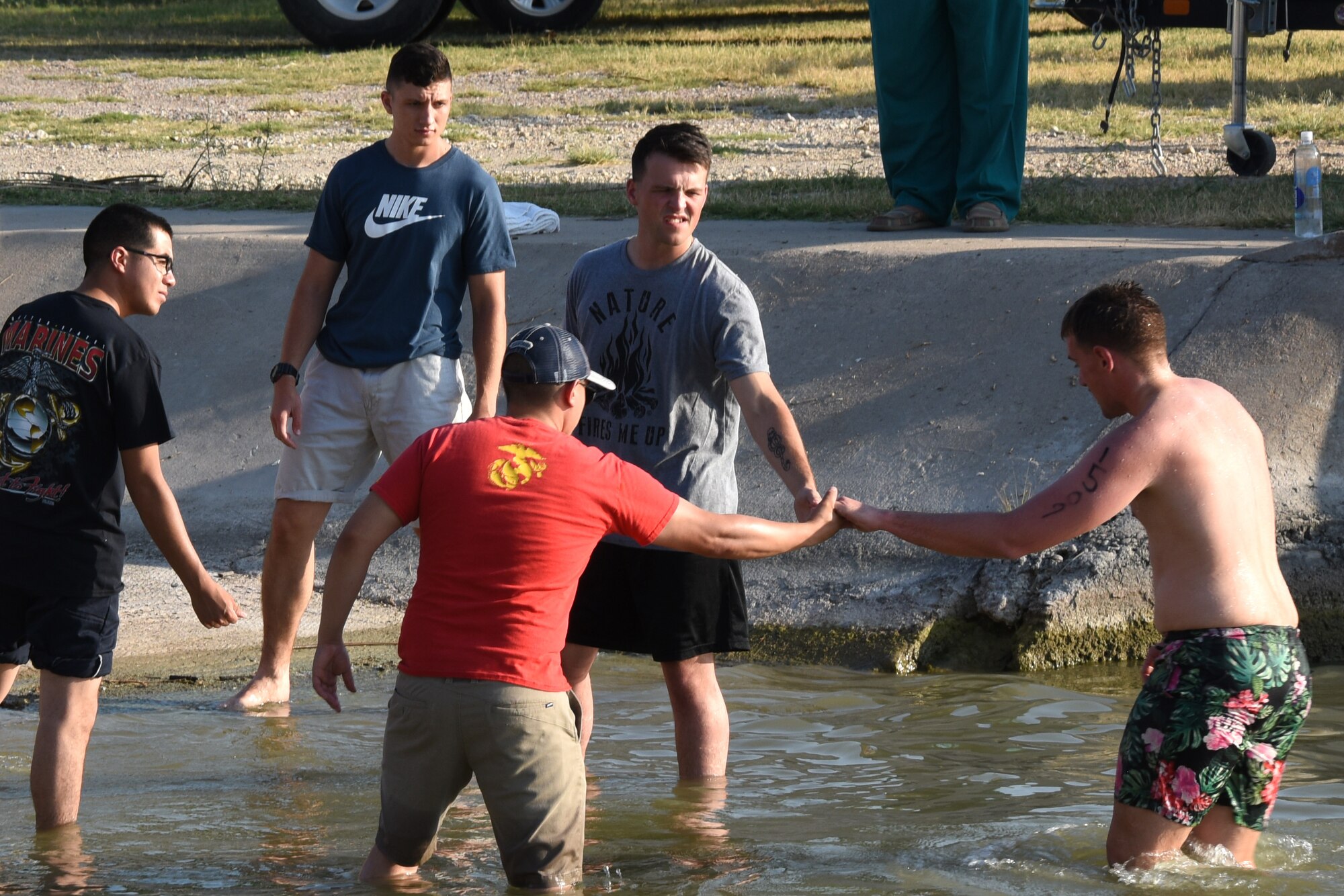 Volunteers help a triathlon participant out of Lake Nasworthy during the Goodfellow Annual Triathlon at the Goodfellow Air Force Base Recreation Camp San Angelo, Texas, July 28, 2018. A 400 meter swim was the first section of the triathlon followed by a 20K bike ride and a 5K run. (U.S. Air Force photo by Airman 1st Class Zachary Chapman/Released)