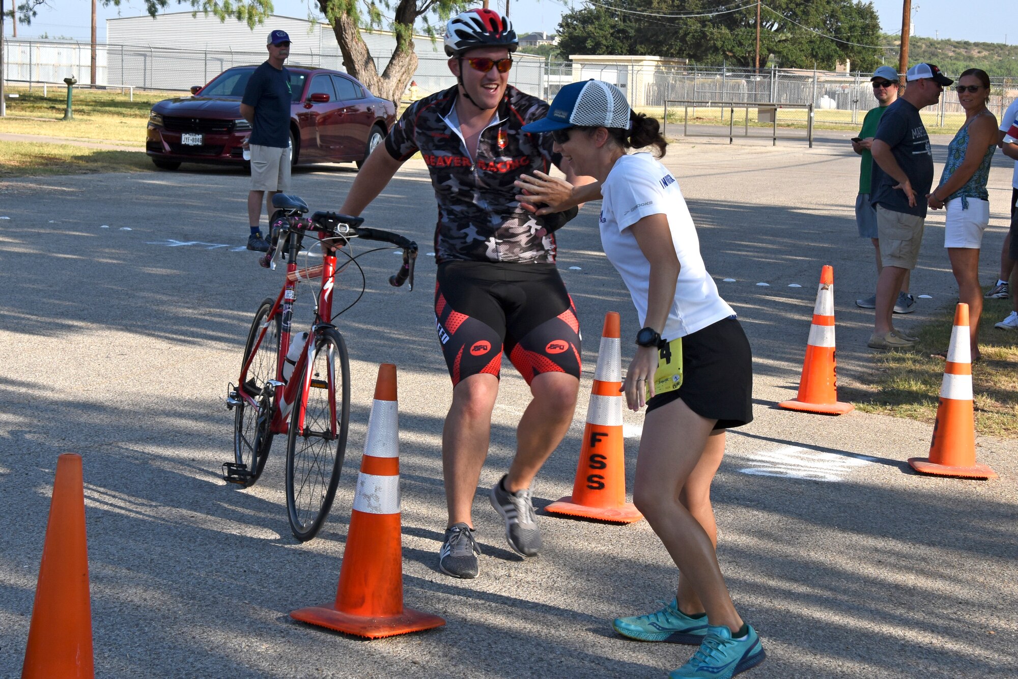 U.S. Air Force Senior Airman Danny Smith, 17th Medical Operations Squadron flight medical technician, tags his teammate Capt. Jennifer Henning, 17th MDOS flight surgeon, during the Goodfellow Annual Triathlon at the Goodfellow Air Force Base Recreation Camp San Angelo, Texas, July 28, 2018. The triathlon was open to members from Goodfellow and San allowing them to test their merit. (U.S. Air Force photo by Airman 1st Class Zachary Chapman/Released)