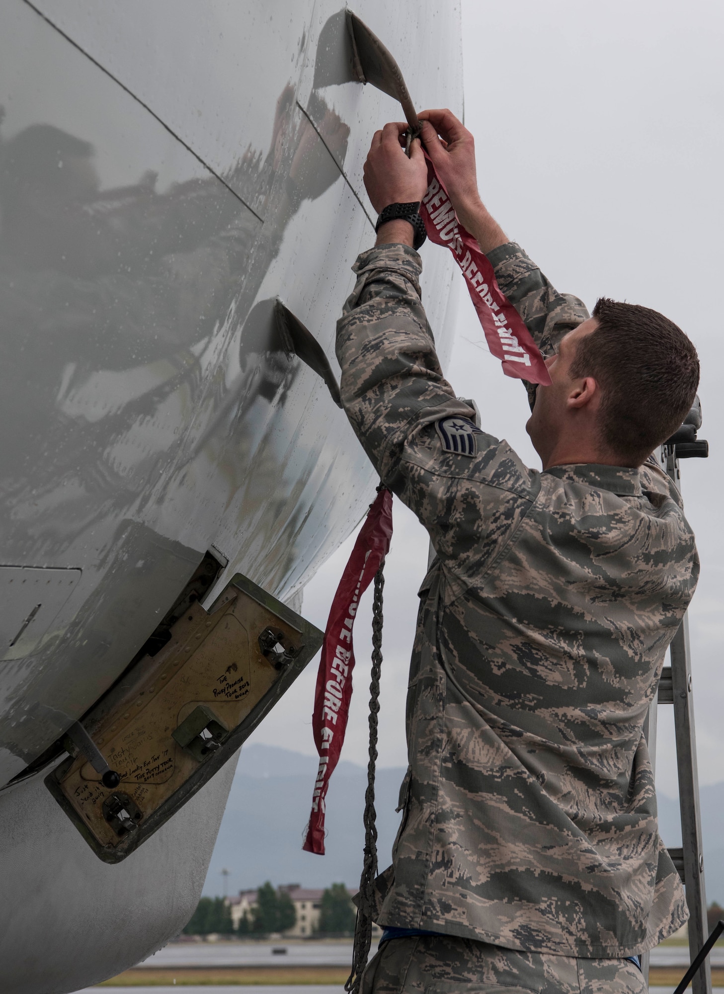 U.S. Air Force Staff Sgt. Matthew Kennedy, a 962nd Aircraft Maintenance Unit E-3 Sentry crew chief, places covers over external sensors at Joint Base Elmendorf-Richardson, Alaska, July 25, 2018. Kennedy is responsible for service and repair on everything coming back from daily inspections, to include things like oil, hydraulics, fueling the jet and ensuring covers are in place.