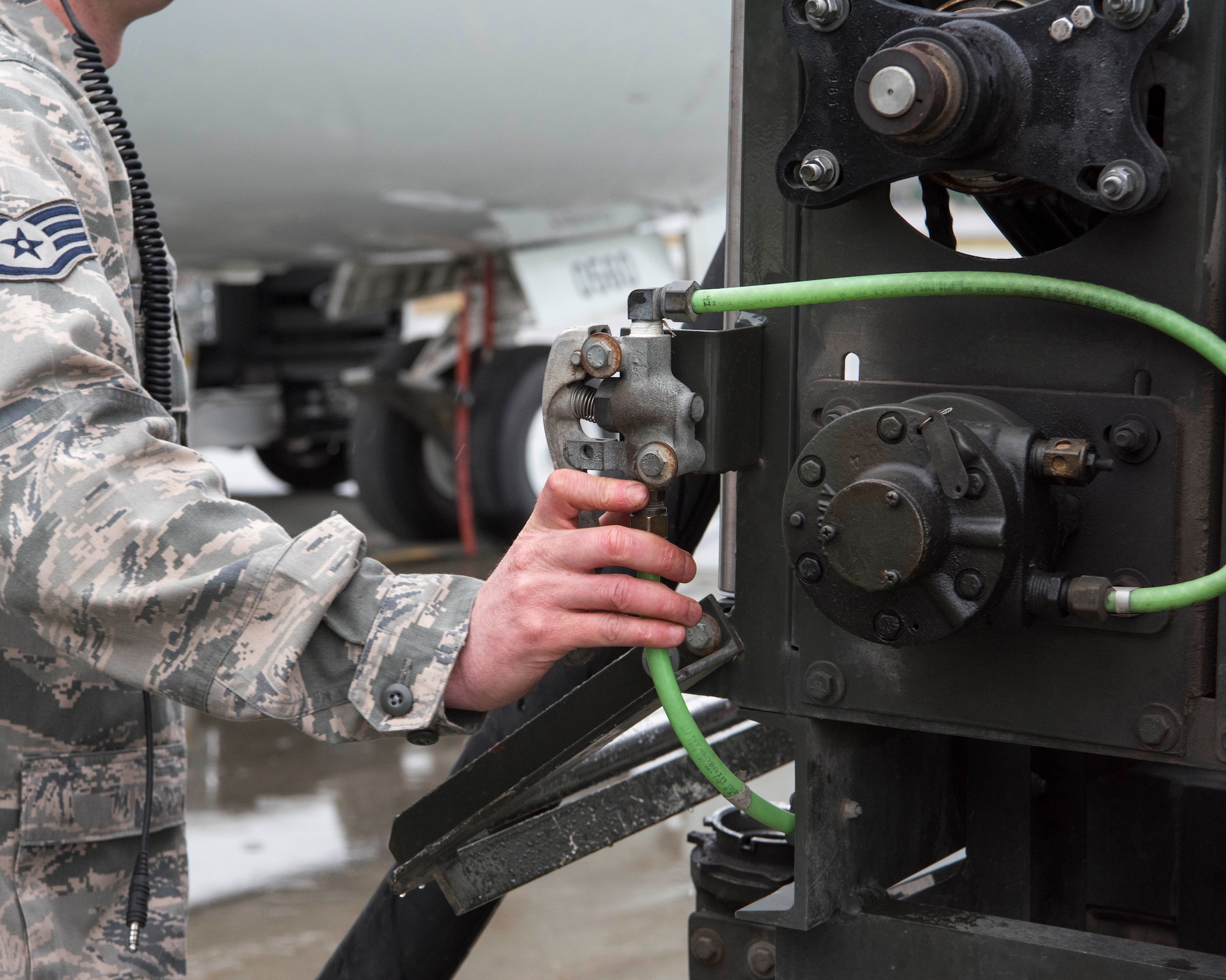 U.S. Air Force Staff Sgt. Matthew Kennedy, a 962nd Aircraft Maintenance Unit E-3 Sentry crew chief, reels in a fuel hose after refueling an E-3 Sentry at Joint Base Elmendorf-Richardson, Alaska, July 25, 2018. Kennedy is responsible for service and repair on everything coming back from daily inspections, to include things like oil, hydraulics and fueling the jet.
