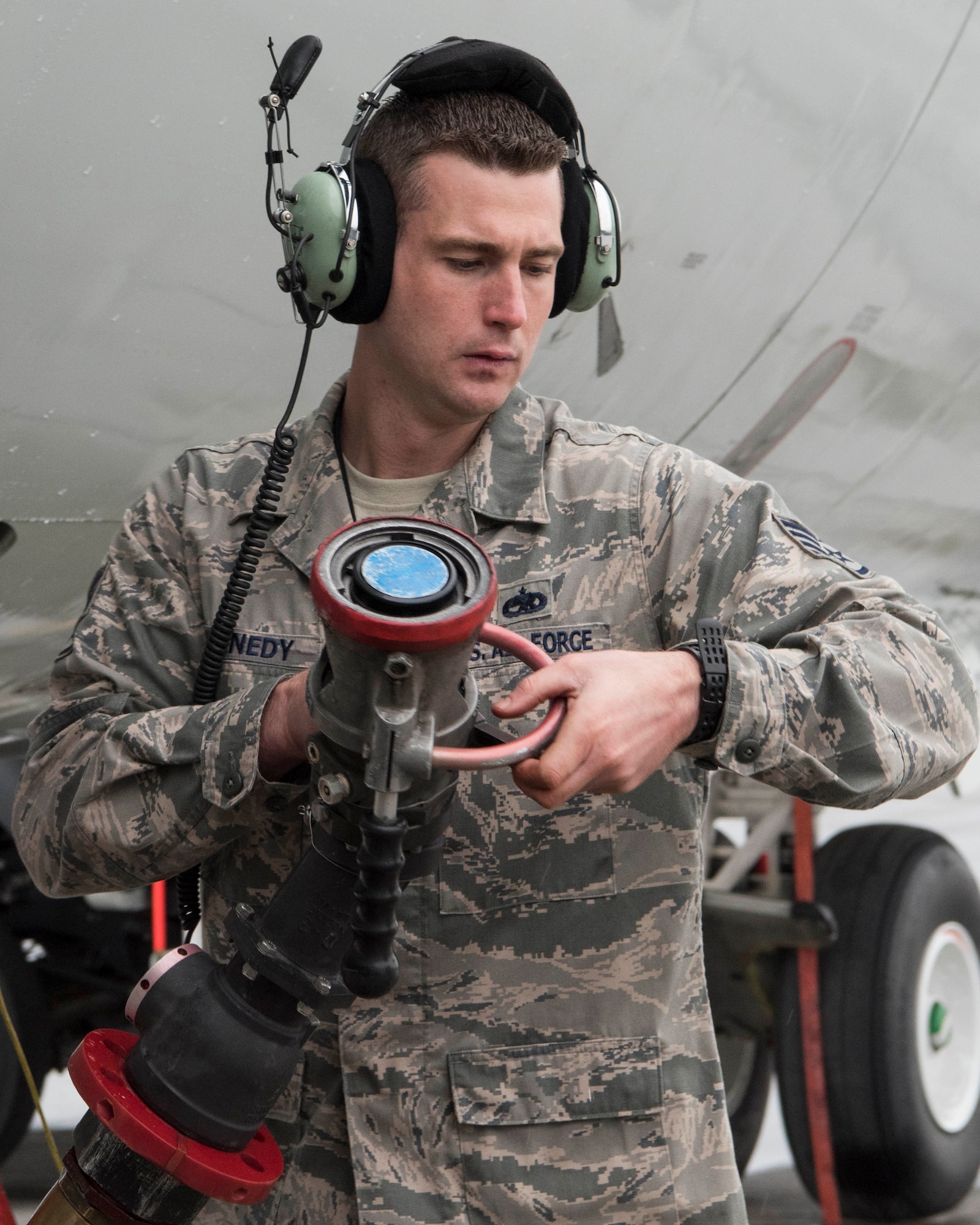 U.S. Air Force Staff Sgt. Matthew Kennedy, a 962nd Aircraft Maintenance Unit E-3 Sentry crew chief, holds a fuel hose at Joint Base Elmendorf-Richardson, Alaska, July 25, 2018. Kennedy is responsible for service and repair on everything coming back from daily inspections, to include things like oil, hydraulics and fueling the jet.