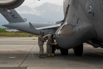 U.S. Air Force Staff Sgt. Silvestre Rojas and Senior Airman Michael Ela, both 517th Aircraft Maintenance Unit communication navigations specialists, test the counter measures dispensing system on a C-17 Globemaster III at Joint Base Elmendorf-Richardson, Alaska, July 26, 2018. During this process, the aircraft is cordoned off and the specialists test the flare dispensers for functionality.