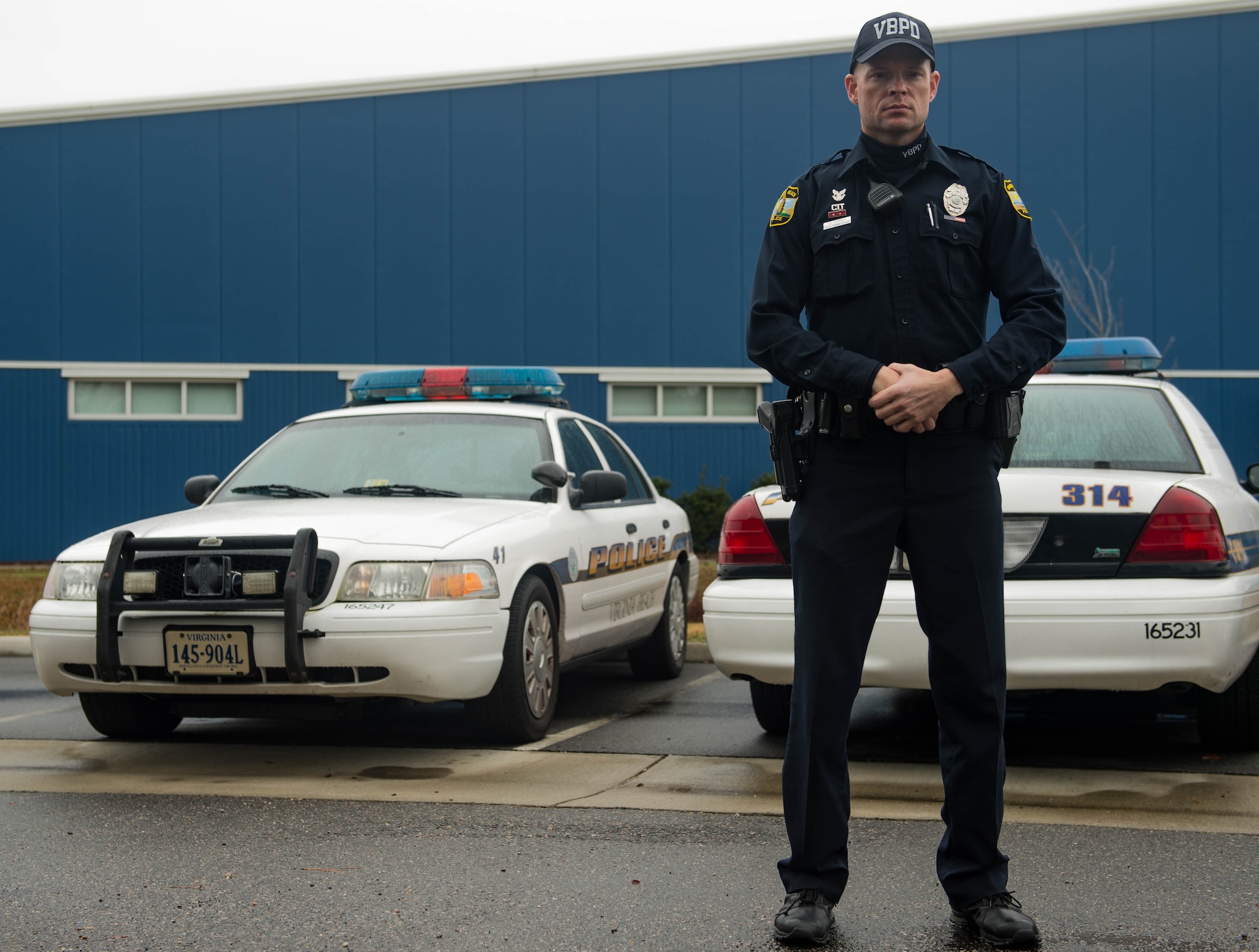 Eli Kendrick, Virginia Police Department master police officer, stands in front of the Ready Response Team’s vehicles in Virginia Beach, Virginia, December 6, 2017. Kendrick also works at Joint Base Langley-Eustis’ 63rd Intelligence Squadron, and was formerly active duty in the U.S. Marine Corps. (U.S. Air Force photo by Senior Airman Derek Seifert)