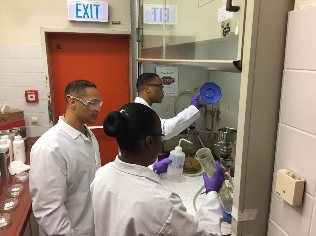 Three US Army soldiers perform fuel quality testing.