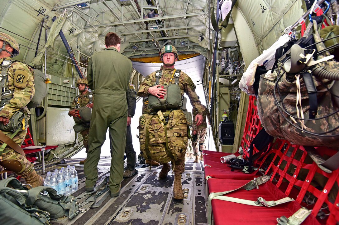 Soldiers board a C-130 Hercules aircraft.