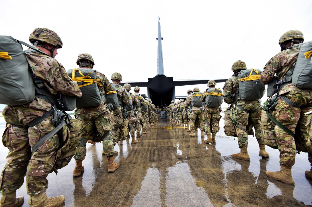 Soldiers prepare to board a C-130 Hercules aircraft.