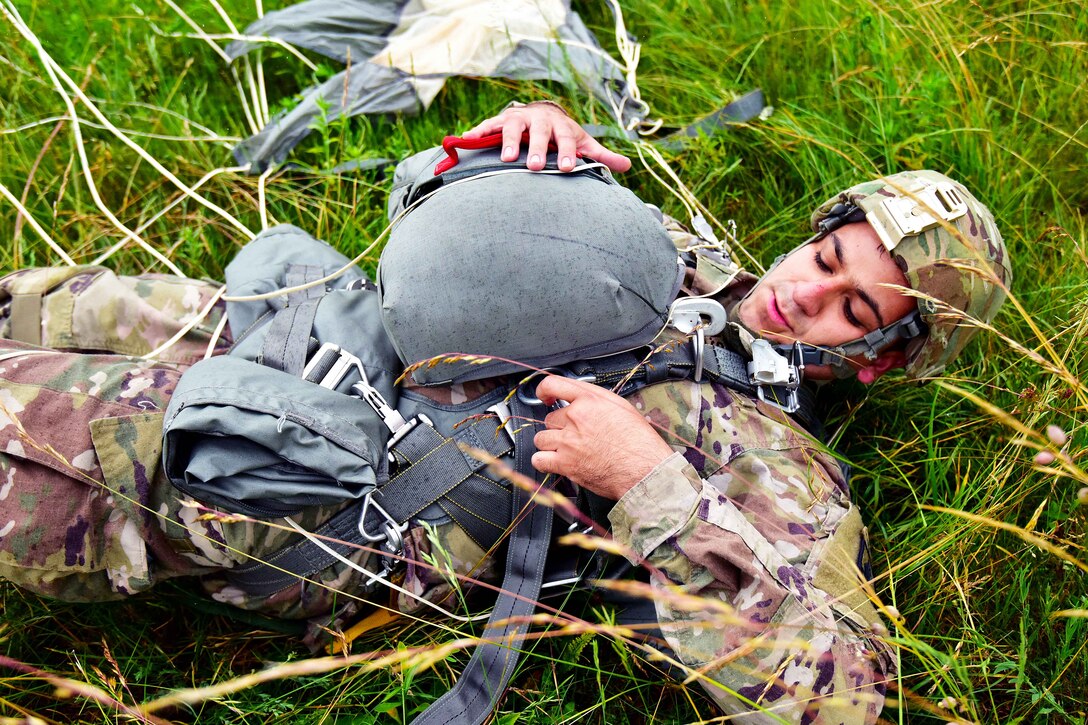 A soldier removes his backup chute during airborne operation.