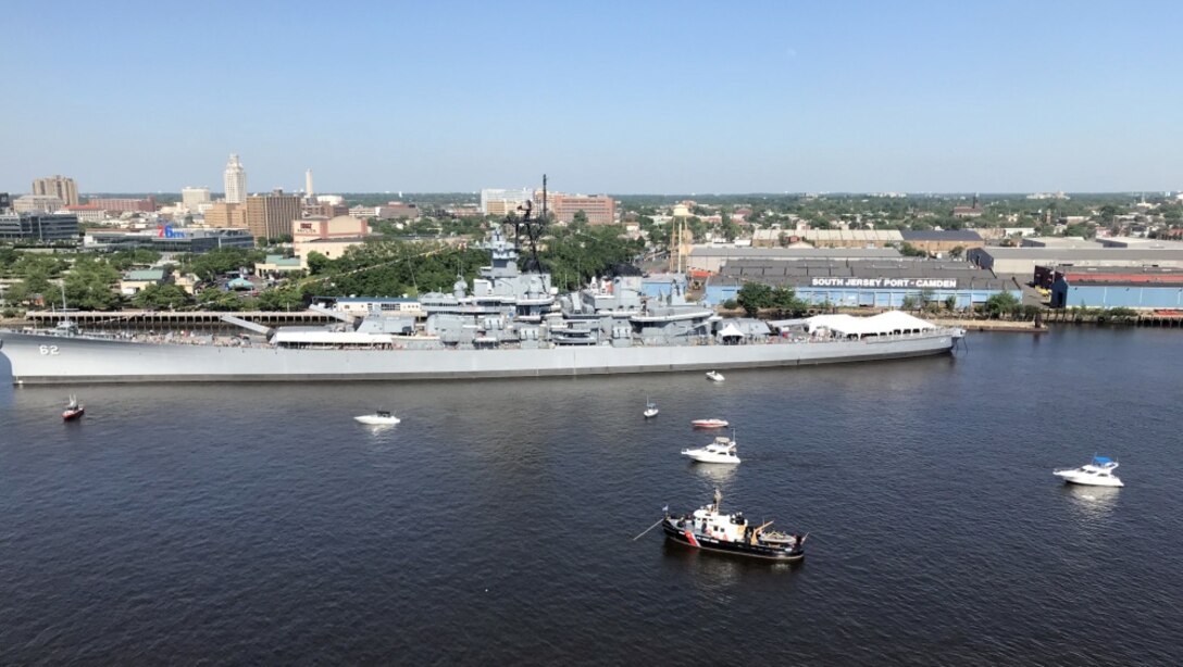 The U.S. Coast Guard Cutter Cleat, lower middle, enforces a safety zone as tall ships from around the world transit the Delaware River in Philadelphia for Sail Philadelphia 2018.