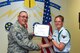 U.S. Air Force Chief Master Sgt. Daniel Stein, 17th Training Group superintendent, presents the 312th Training Squadron Student of the Month award to Airman 1st Class Cynthia Schroll, 312th TRS trainee, at Brandenburg Hall on Goodfellow Air Force Base, Texas, June 1, 2018. The 312th TRS’s mission is to provide Department of Defense and international customers with mission ready fire protection and special instruments graduates and provide mission support for the Air Force Technical Applications Center. (U.S. Air Force photo by Airman 1st Class Zachary Chapman/Released)