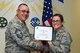 U.S. Air Force Chief Master Sgt. Daniel Stein, 17th Training Group superintendent, presents the 315th Training Squadron Officer Student of the Month award to 2nd Lt. Elisabeth Miller, 315th TRS trainee, at Brandenburg Hall on Goodfellow Air Force Base, Texas, June 1, 2018. The 315th TRS’s vision is to develop combat-ready intelligence, surveillance and reconnaissance professionals and promote an innovative squadron culture and identity unmatched across the U.S. Air Force. (U.S. Air Force photo by Airman 1st Class Zachary Chapman/Released)