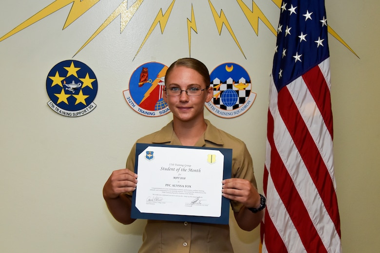 17th Training Group Student of the Month spotlight for May 2018, U.S. Marine Corps Pfc. Alyssa Fox, 316th Training Squadron trainee, hold her award in front of a mural at Brandenburg Hall on Goodfellow Air Force Base, Texas, June 1, 2018. Fox is the Goodfellow Student of the Month spotlight for May 2018, a series highlighting Goodfellow students. (U.S. Air Force photo by Airman 1st Class Zachary Chapman/Released)