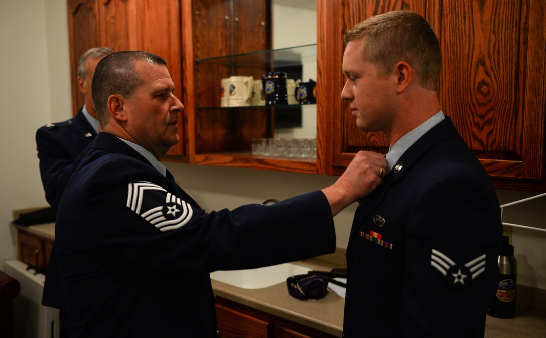 Chief Master Sgt. Allan Turk, 47th Operations Support Squadron radar approach control chief controller, double-checks his son, Senior Airman Mitchel Turk’s uniform before the commencement of the chief’s retirement ceremony at Laughlin Air Force Base, Texas, June 1, 2018. After serving for 30 years in the Air Force, Turk retires, wishing that he had just one more year to serve beside his wingmen. (U.S. Air Force photo by Senior Airman Benjamin N. Valmoja)