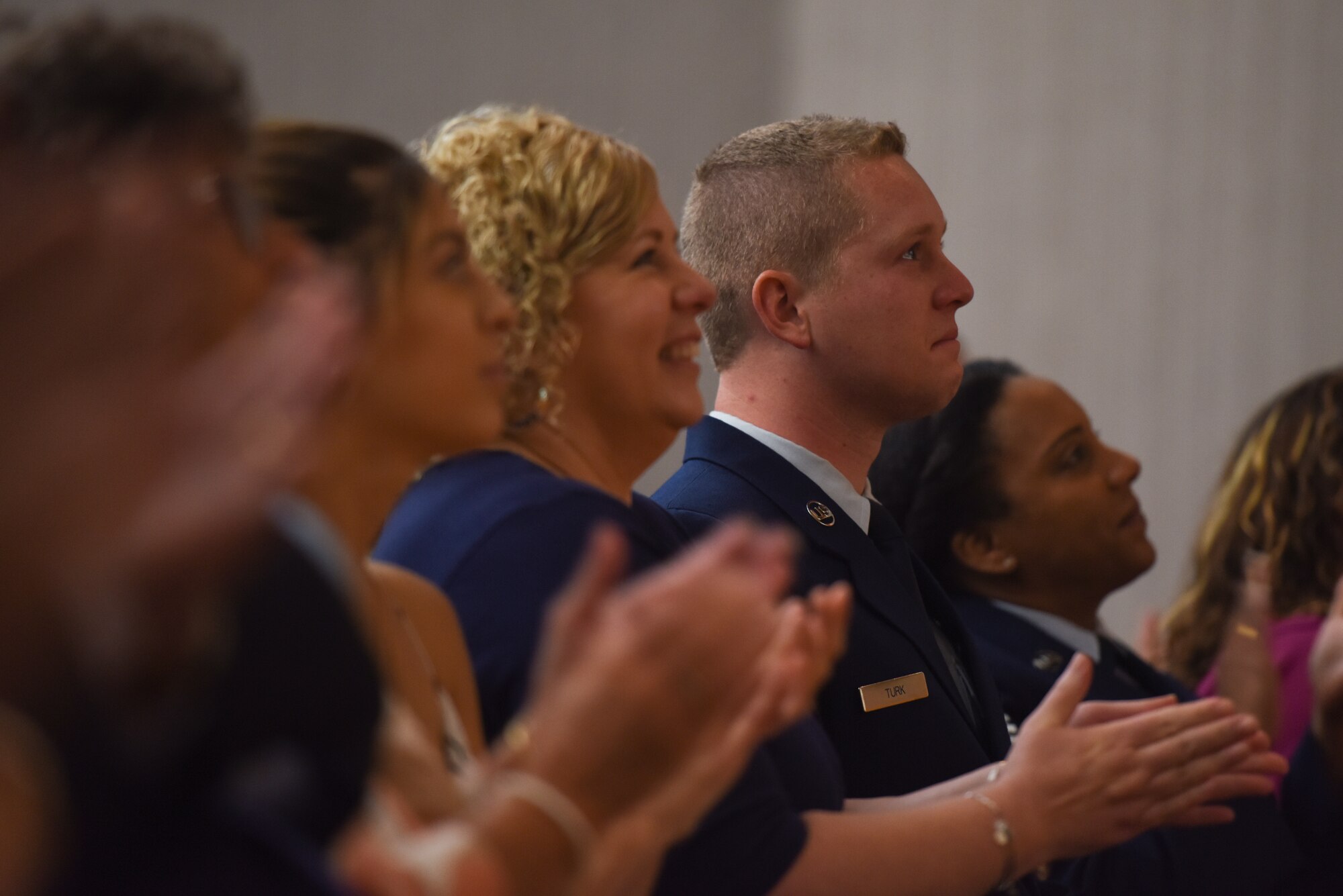 Senior Airman Mitchel Turk, 603rd Air and Space Operations Center, Ramstein Air Base, Germany, watches with pride as the final slides for his father’s retirement ceremony make their way across the screen at Laughlin Air Force Base, Texas, June 1, 2018. His father, Chief Master Sgt. Allan Turk, 47th Operations Support Squadron radar approach control chief controller, served for 30 years and has finally retired. (U.S. Air Force photo by Senior Airman Benjamin N. Valmoja)