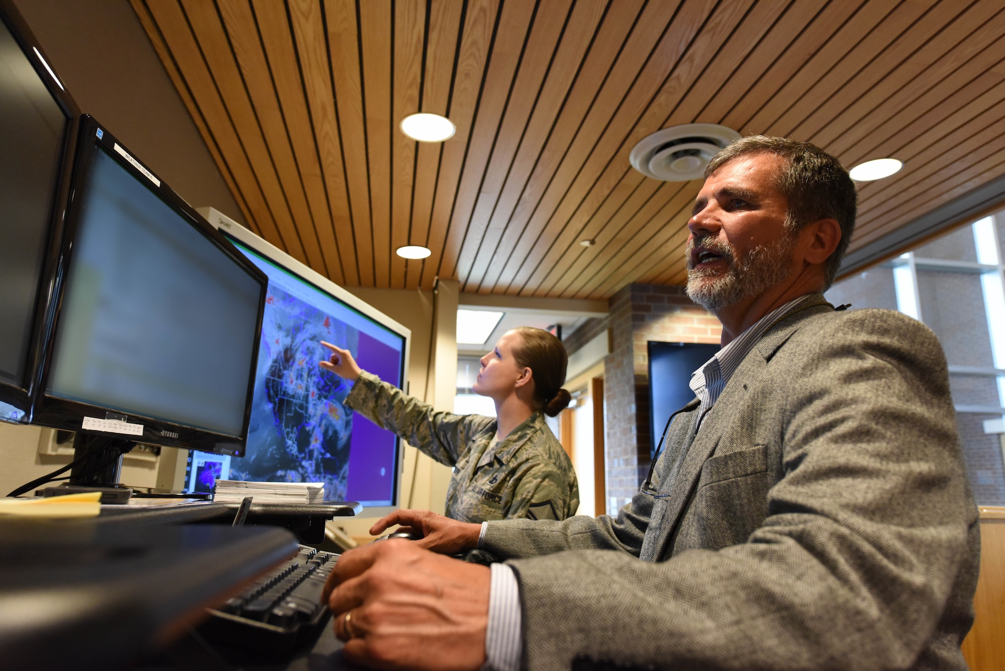 William Martin, the 28th Operations Support Squadron weather flight lead forecaster and Master Sgt. Jessica Leiker, the 28th OSS noncommissioned officer in charge of mission weather operations, observe weather forecasts at Ellsworth Air Force Base, S.D., May 29, 2018. The weather flight is responsible for providing accurate and timely weather forecasts to support operations on base which are critical to mission success. (U.S. Air Force photo by Airman 1st Class Thomas Karol)