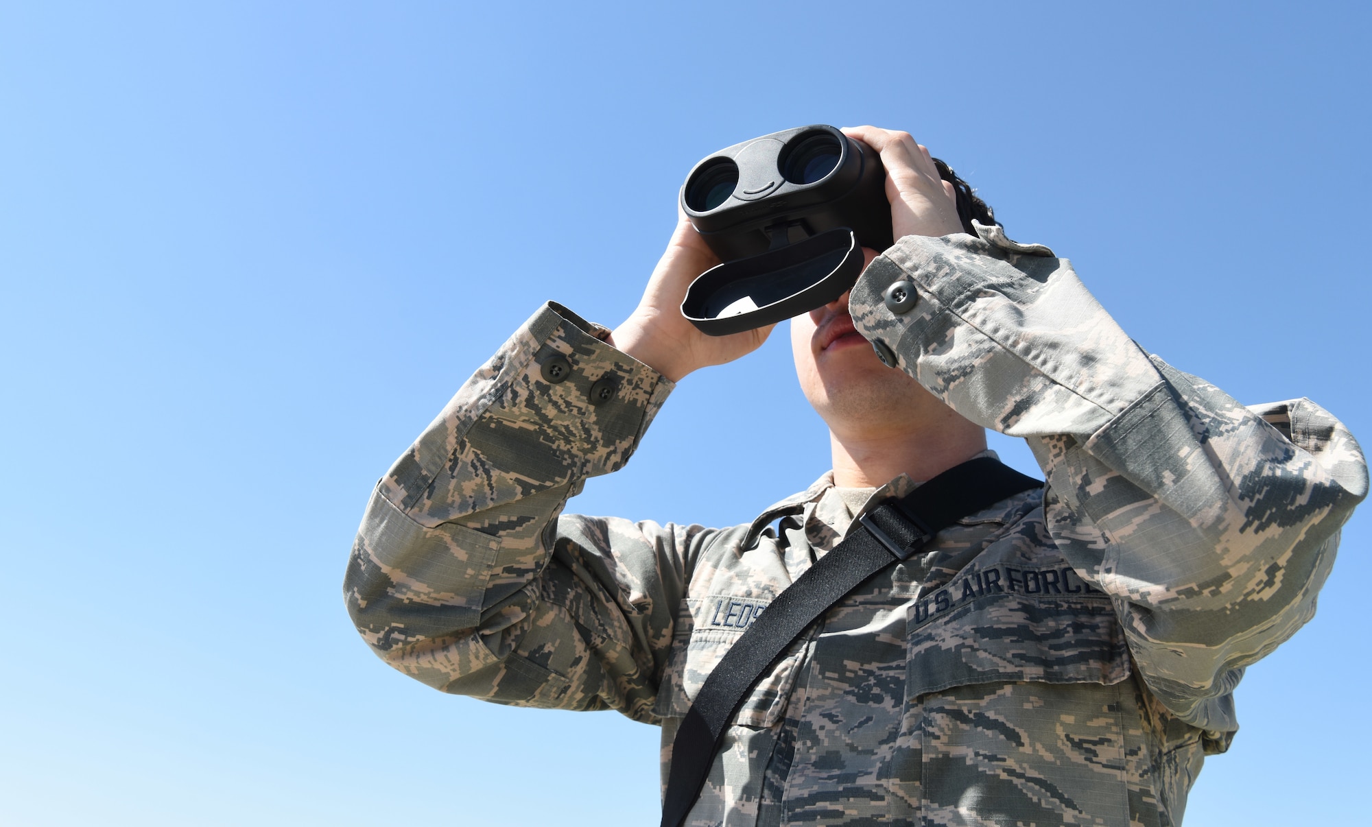 Airman James Leos, 28th Operations Support Squadron weather apprentice, uses a pair of binoculars with a laser range finder to help forecast weather conditions at Ellsworth Air Force Base, S.D, May 30, 2018. The weather flight has to stay on the lookout for changing weather conditions so the flying mission is not affected by any surprise changes in the weather. (U.S. Air Force photo by Airman 1st Class Thomas Karol)