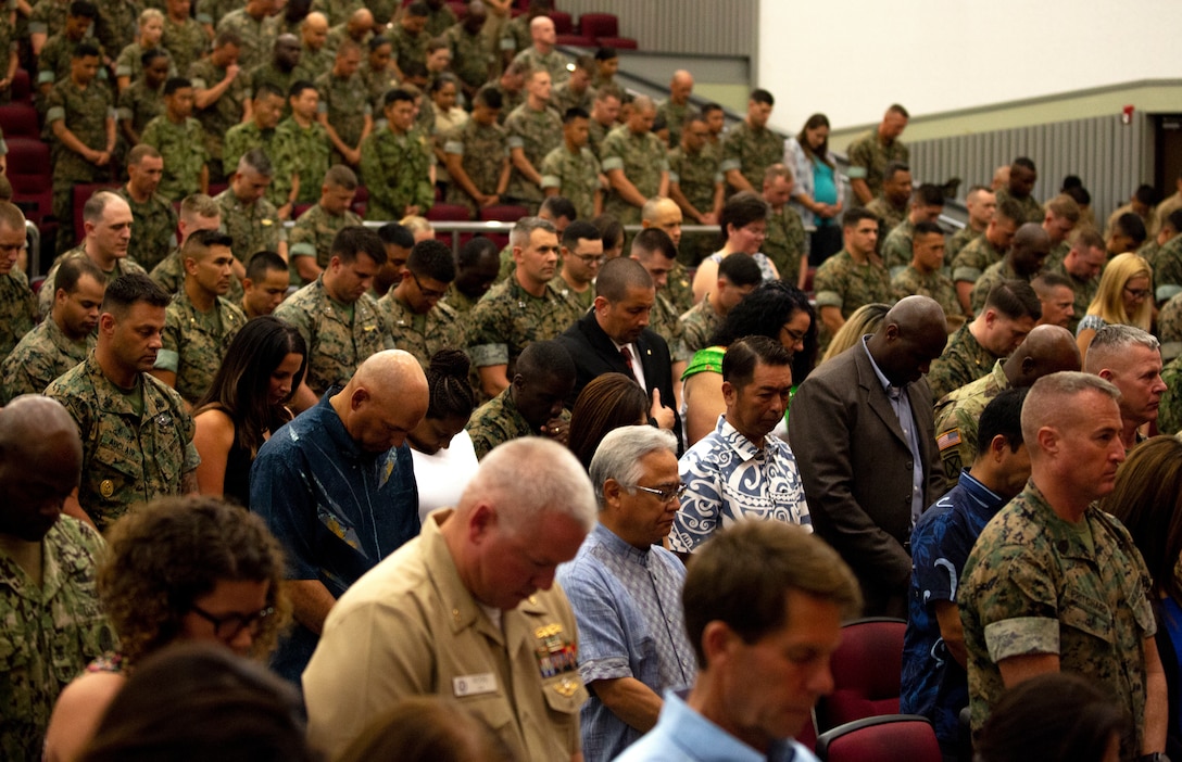 Marines and Sailors of 3rd Marine Logistics Group, family members and guests bow their heads during the invocation as part of the transfer of command ceremony June 1, 2018 at Camp Foster, Okinawa, Japan. Brig. Gen. Daniel B. Conley, commanding general of 3rd MLG, relinquished command of 3rd MLG to Col. Ronald C. Braney, the incoming commanding officer of 3rd MLG. Conley is a native of Falmouth, Massachusetts. Braney is a native of Manlius, New York. (U.S. Marine Corps photo by Cpl. Joshua Pinkney)
