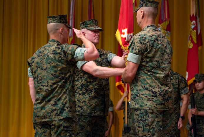 Brig. Gen. Daniel B. Conley, center, outgoing commanding general of 3rd Marine Logistics Group, passes the 3rd MLG colors to Col. Ronald C. Braney, incoming commanding officer of 3rd MLG, during a transfer of command ceremony June 1, 2018 at Camp Foster, Okinawa, Japan. The passing of the colors symbolizes the official transfer of the unit from one commander to the next. Conley is a native of Falmouth, Massachusetts. Braney is a native of Manlius, New York. (U.S. Marine Corps photo by Cpl. Joshua Pinkney)