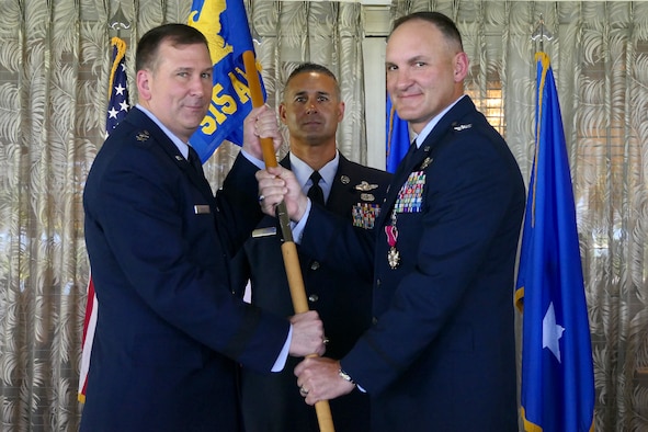 Maj. Gen. Christopher Bence (left), commander of the U.S. Air Force Expeditionary Center, presents Col. Craig Harmon with the 515th Air Mobility Operations Wing guidon as he assumes command of 515th AMOW during a change of command ceremony at Joint Base Pearl Harbor-Hickam, Hawaii, June 1, 2018. 515th AMOW Command Chief Master Sgt. Todd Donaldson is pictured center. Harmon, formerly vice commander of the 515th AMOW, assumed command from Col. Scott Zippwald, who retired after more than 26 years of service in the U.S. Air Force.