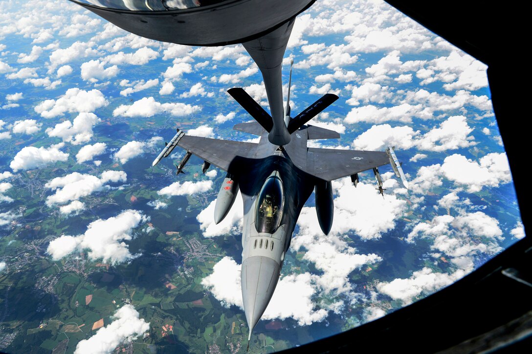 An aircraft receives fuel from the boom of another aircraft while in flight.