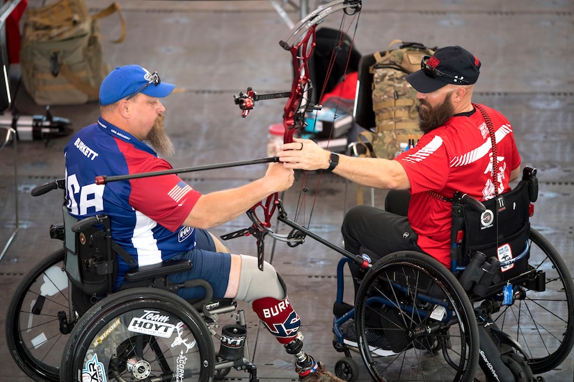 A Marine passes a bow to his team member.