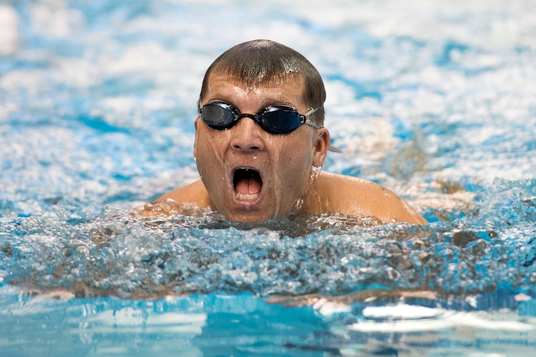 A warrior athlete trains in the breaststroke during swimming practice.