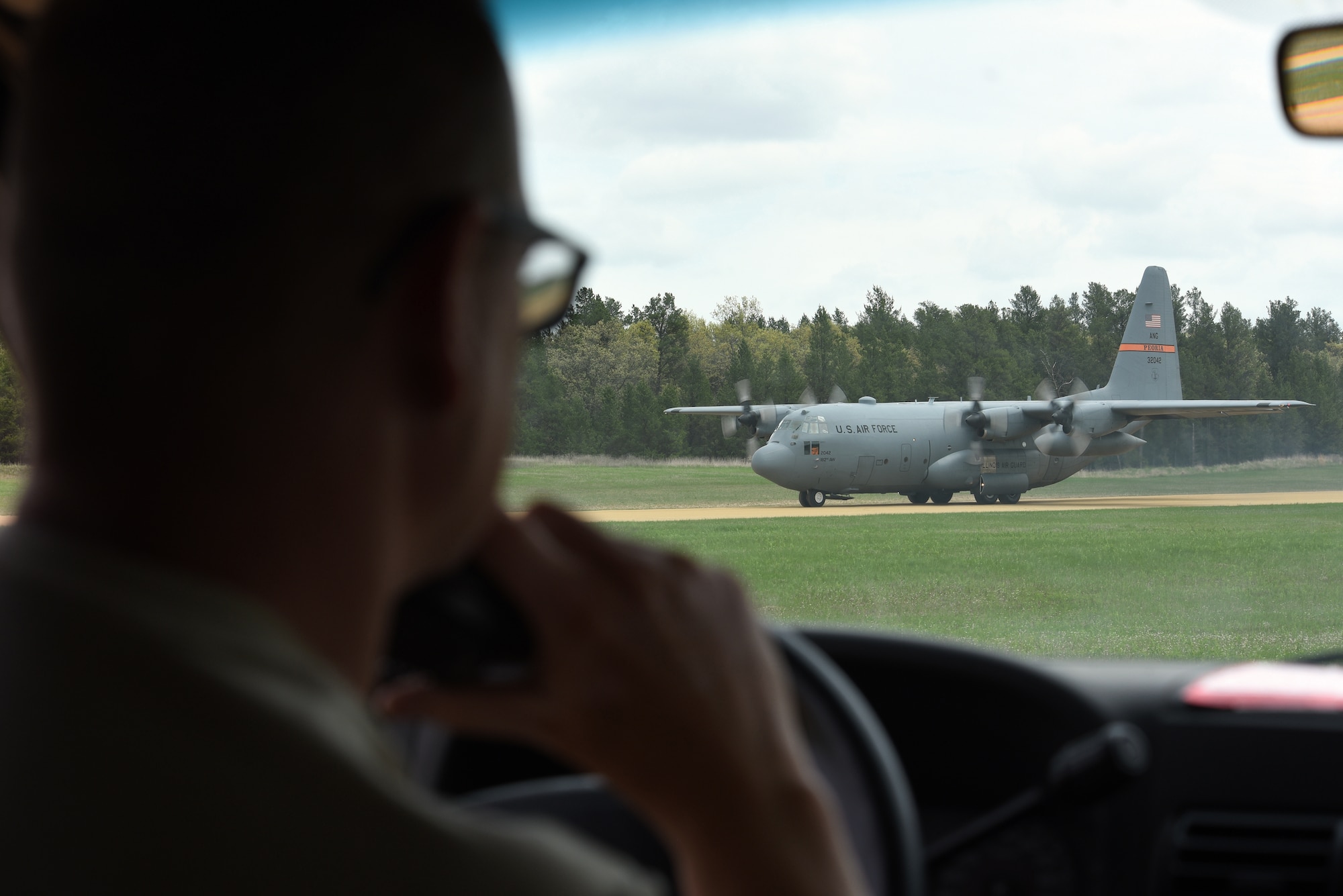 U.S. Air Force Senior Master Sgt. Brent Bixby, an airfield management superintendent with the 182nd Airlift Wing, Illinois Air National Guard, communicates via radio to the pilot of a C-130 Hercules as it taxis at Young Landing Zone at Fort McCoy, Wis. May 14, 2018. A number of pilots were qualifying to complete their unimproved landing certification. (U.S. Air National Guard photo by Master Sgt. Todd A. Pendleton)
