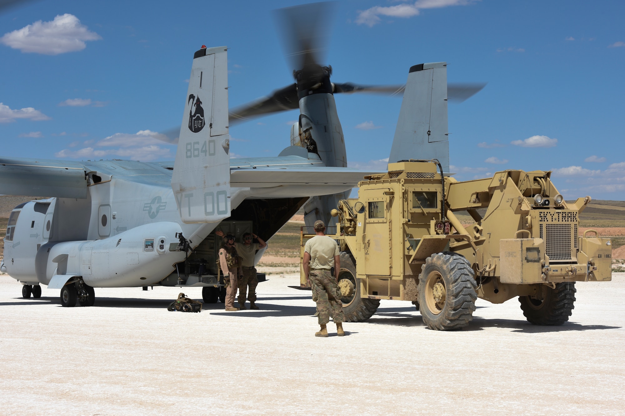 Aerial ports personnel from the 441st Air Expeditionary Squadron, download a U.S. Marine Corps MV-22 Osprey at an undisclosed location, May 18, 2018. The 441st AES aerial port flight performs all operations on the landing zone to include processing cargo and personnel. (U.S. Air Force photo by Tech. Sgt. Caleb Pierce)